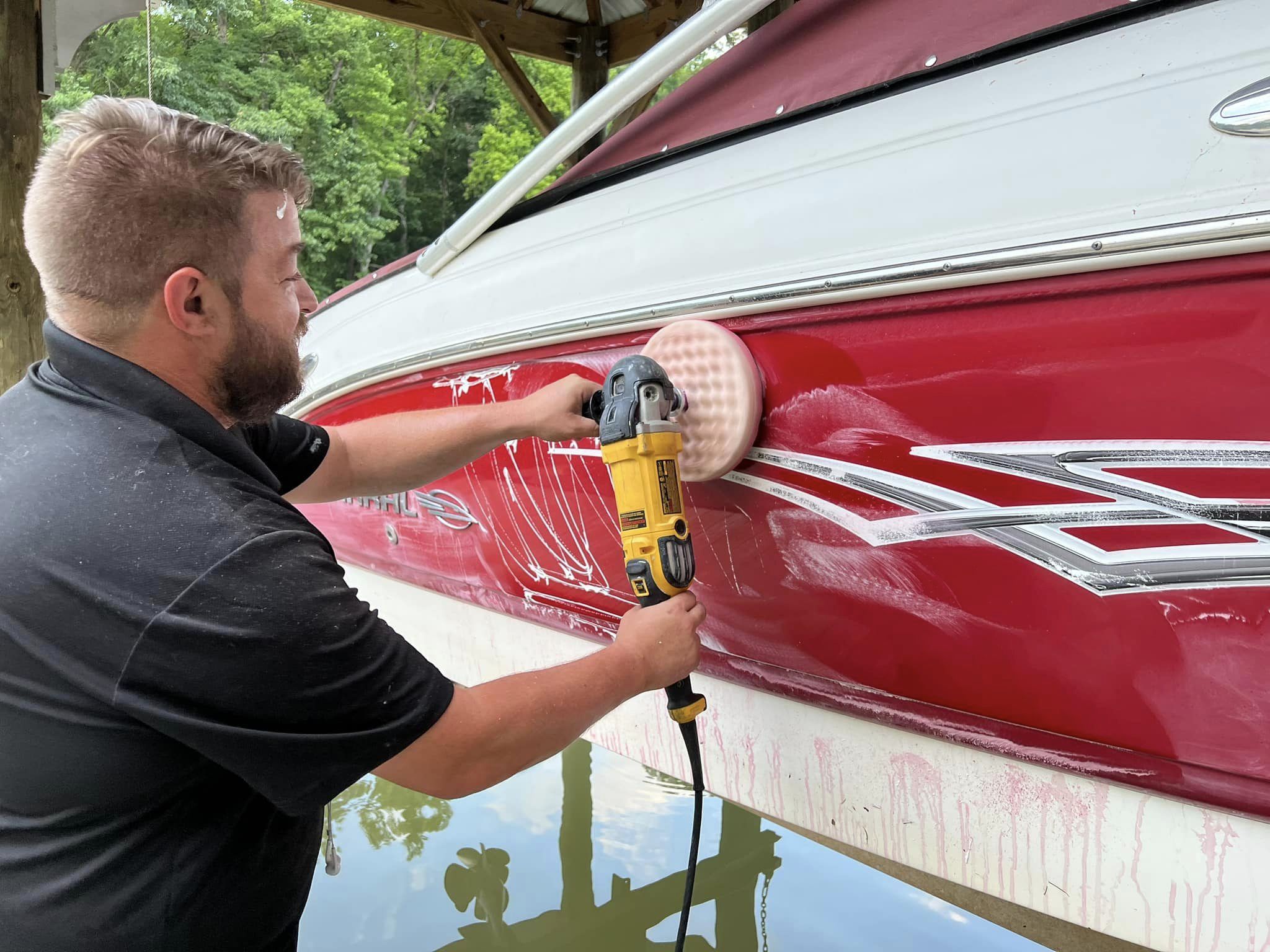Detailer polishing a boat hull by hand
